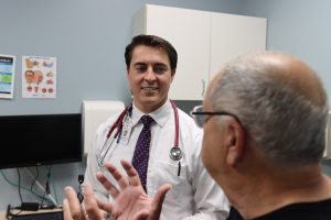 young doctor meeting with patient in exam room