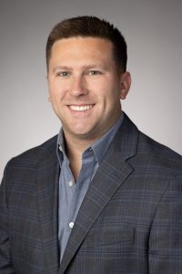 a man in a suite smiling for a headshot