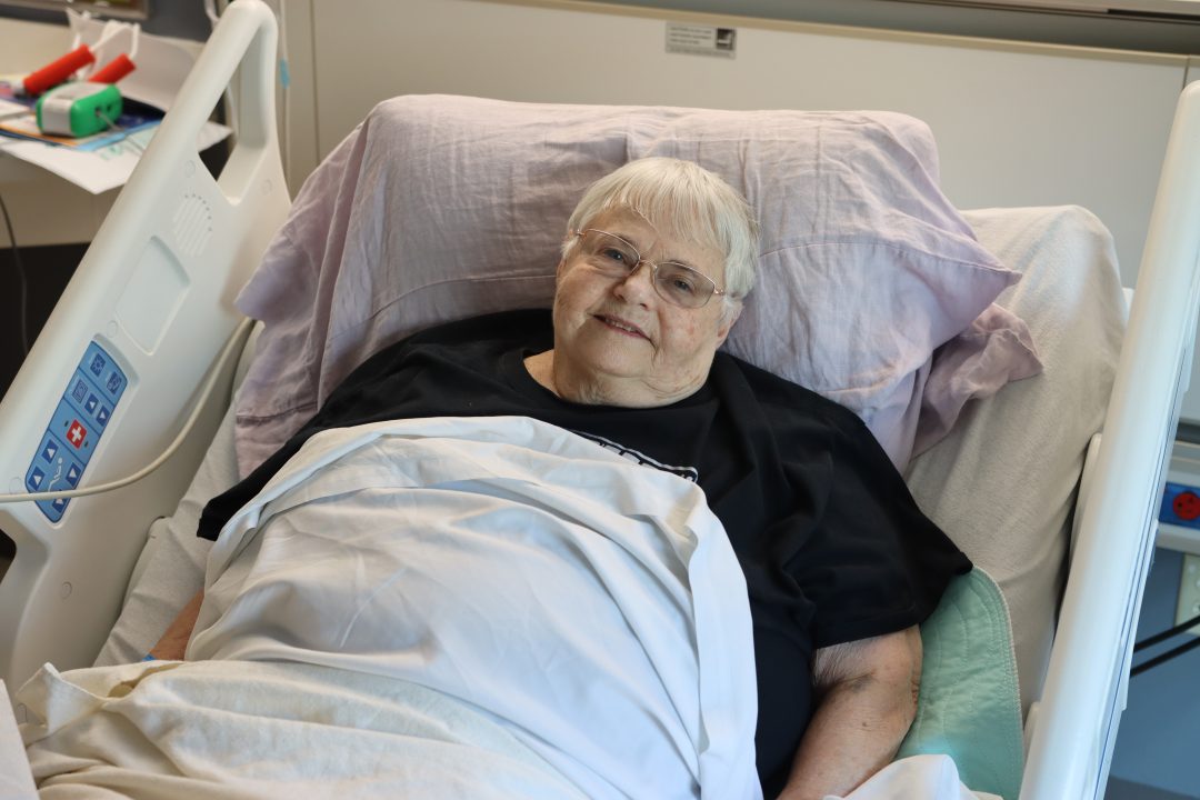 a woman lying in an NMC Health hospital bed