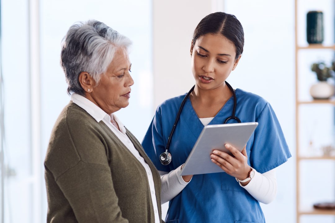 a woman and a doctor looking wellness baseline on a tablet