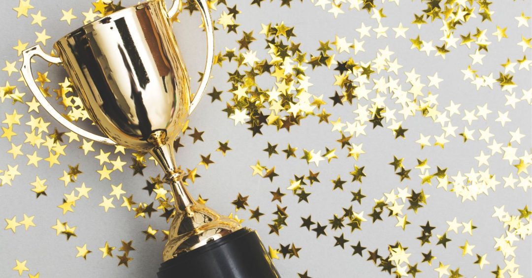 gold trophy with a gold stars scattered through background signifying NMC Health's recognition for quality care.
