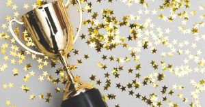 gold trophy with a gold stars scattered through background signifying NMC Health's recognition for quality care.