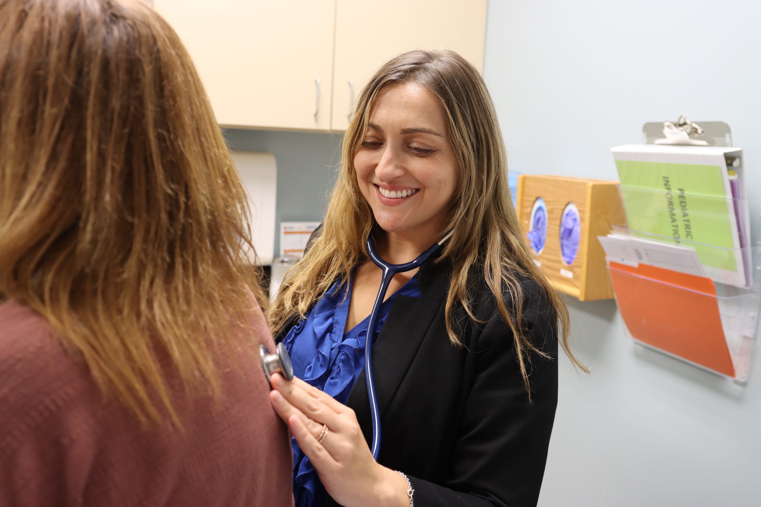Female doctor checking out a patients breathing with a stethoscope at a scheduled doctor appointment.